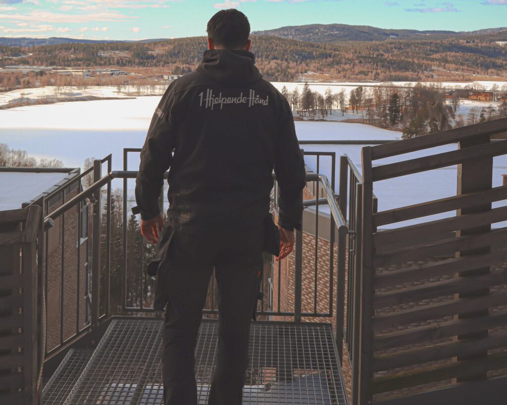 Medarbeider fra 1 Hjelpende Hånd får oversikt fra en terrasse med utsikt over landskapet